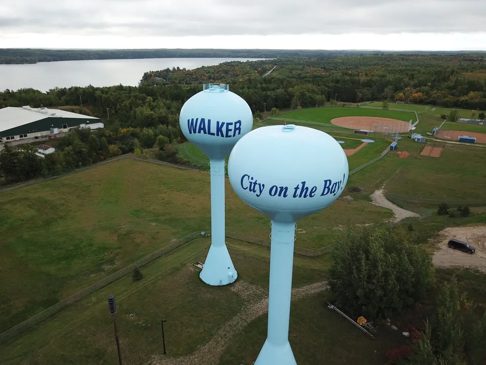 Aerial photo showcasing Walker's twin water towers against lush greenery and serene water backdrop.