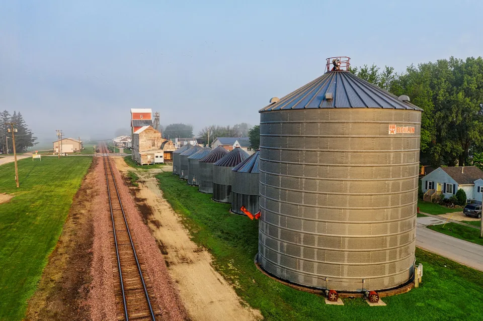 Aerial shot capturing grain silos and railroad tracks in rural Utica, Minnesota.