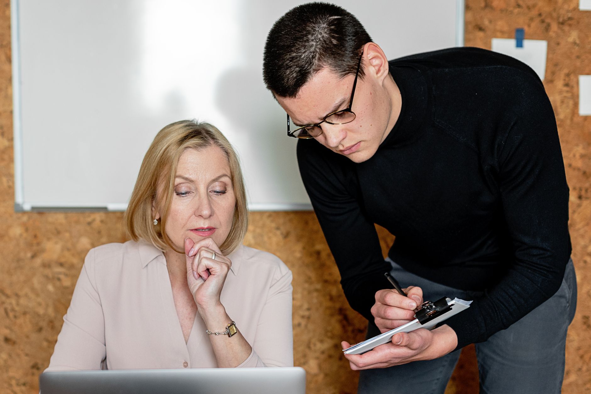 Two colleagues collaborating during a business meeting, focused on planning and communication.